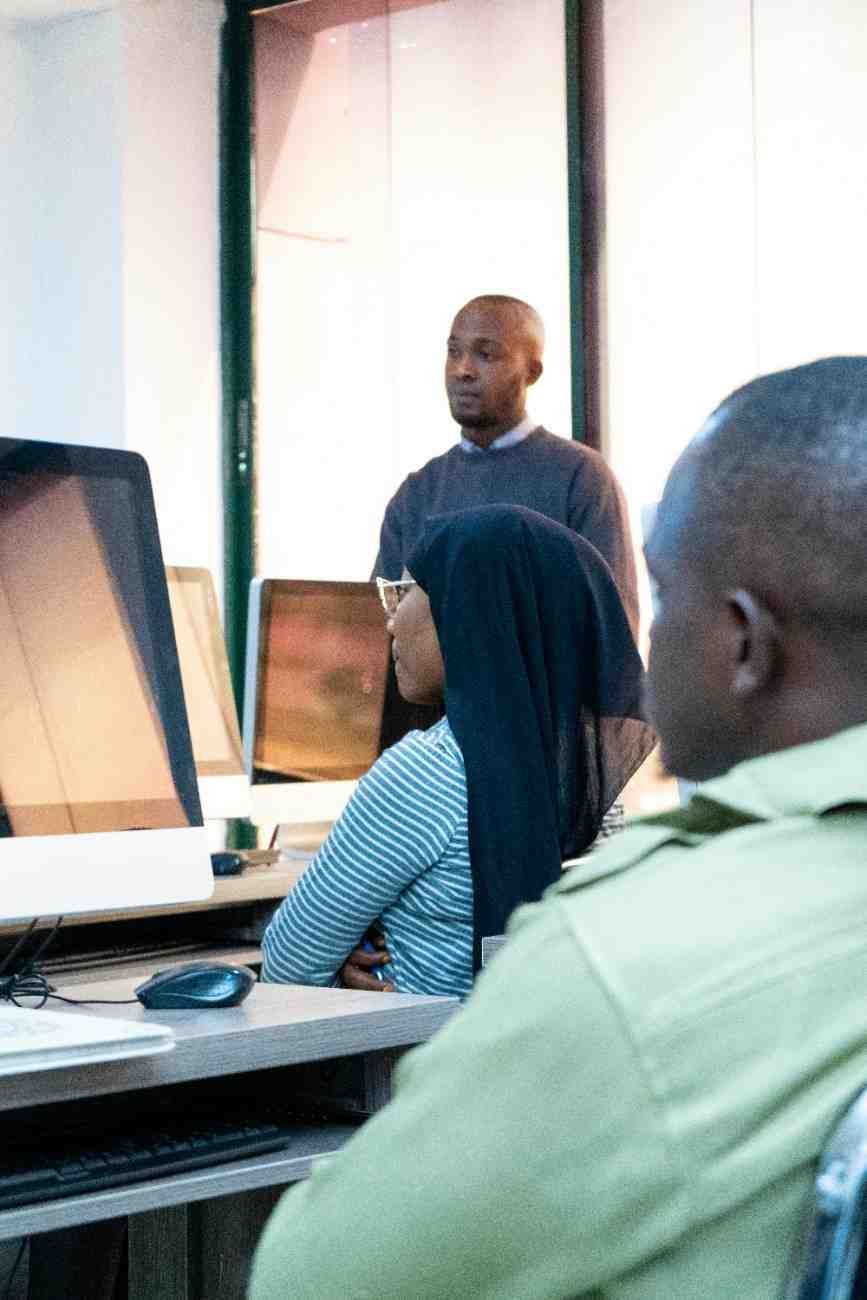 Class of students with laptops and a teacher